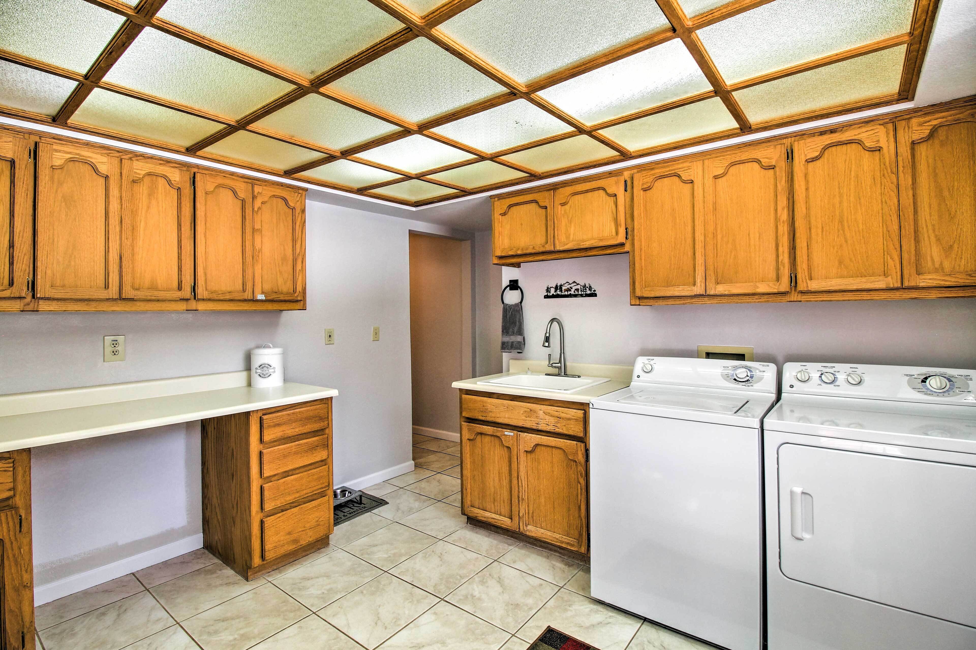 A kitchen with wooden cabinets, a countertop, a sink, a stove, and a dishwasher.
