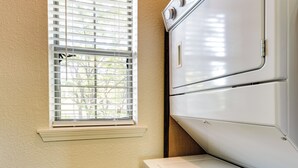 A laundry area with a white dryer and a window with blinds. - Family-friendly Branson Condo w/ Golf Course Views (Branson West)
