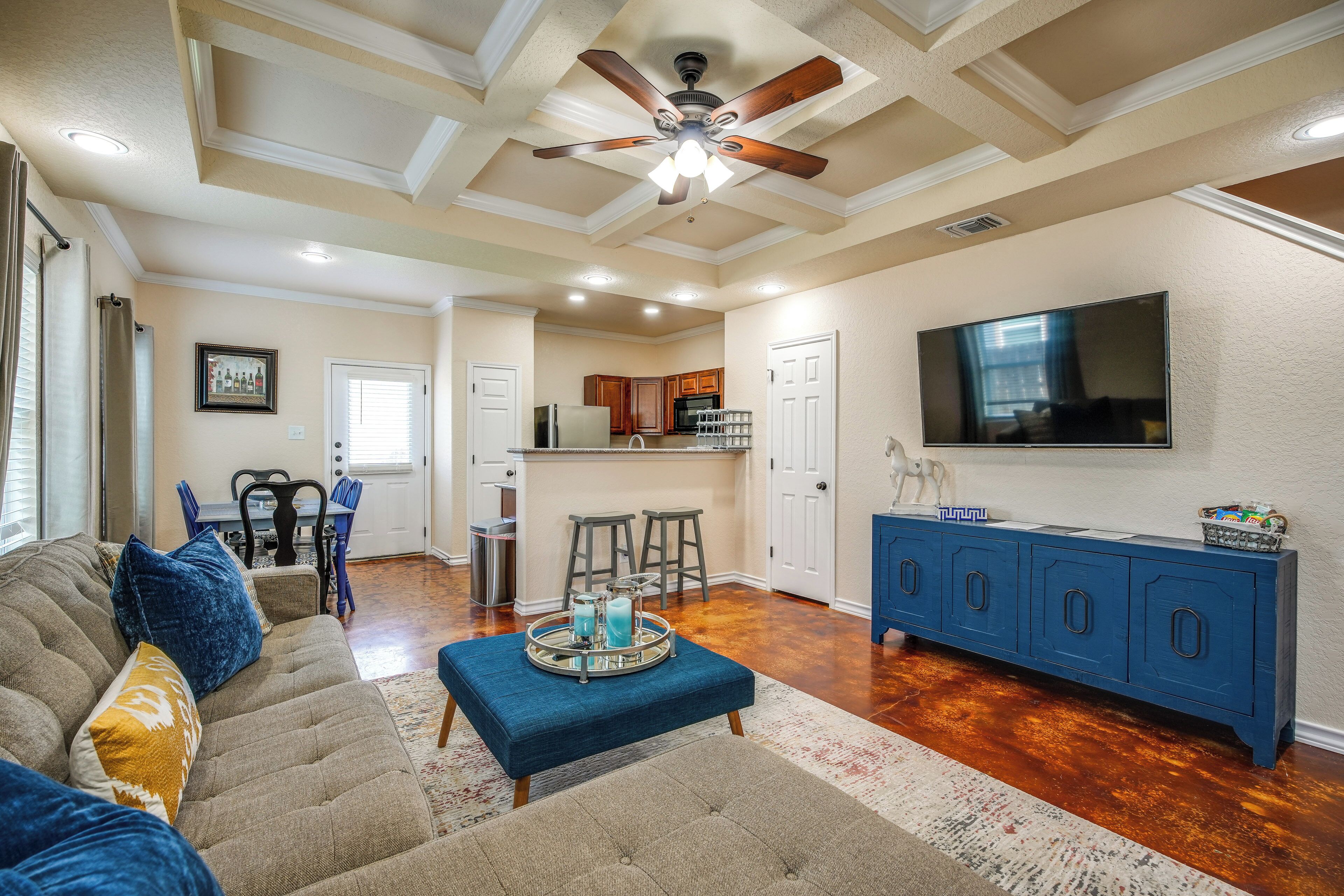A spacious living area with a sofa, ottoman, and a blue cabinet.