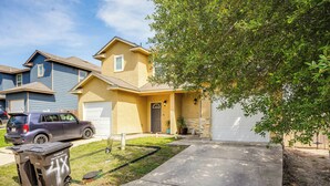 A residential house with a garage, a driveway, and a parked SUV. - San Antonio Townhome ~ 2 Mi to Aquarium! (San Antonio)