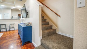 A staircase with carpeted steps leading to a landing, a blue cabinet with drawers, a mirror, and a light switch on the wall. - San Antonio Townhome ~ 2 Mi to Aquarium! (San Antonio)