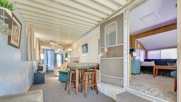 A caravan interior with a dining area, a sofa, and a kitchen. - Cozy Yuma Vacation Rental w/ Resort Amenities! (Yuma)