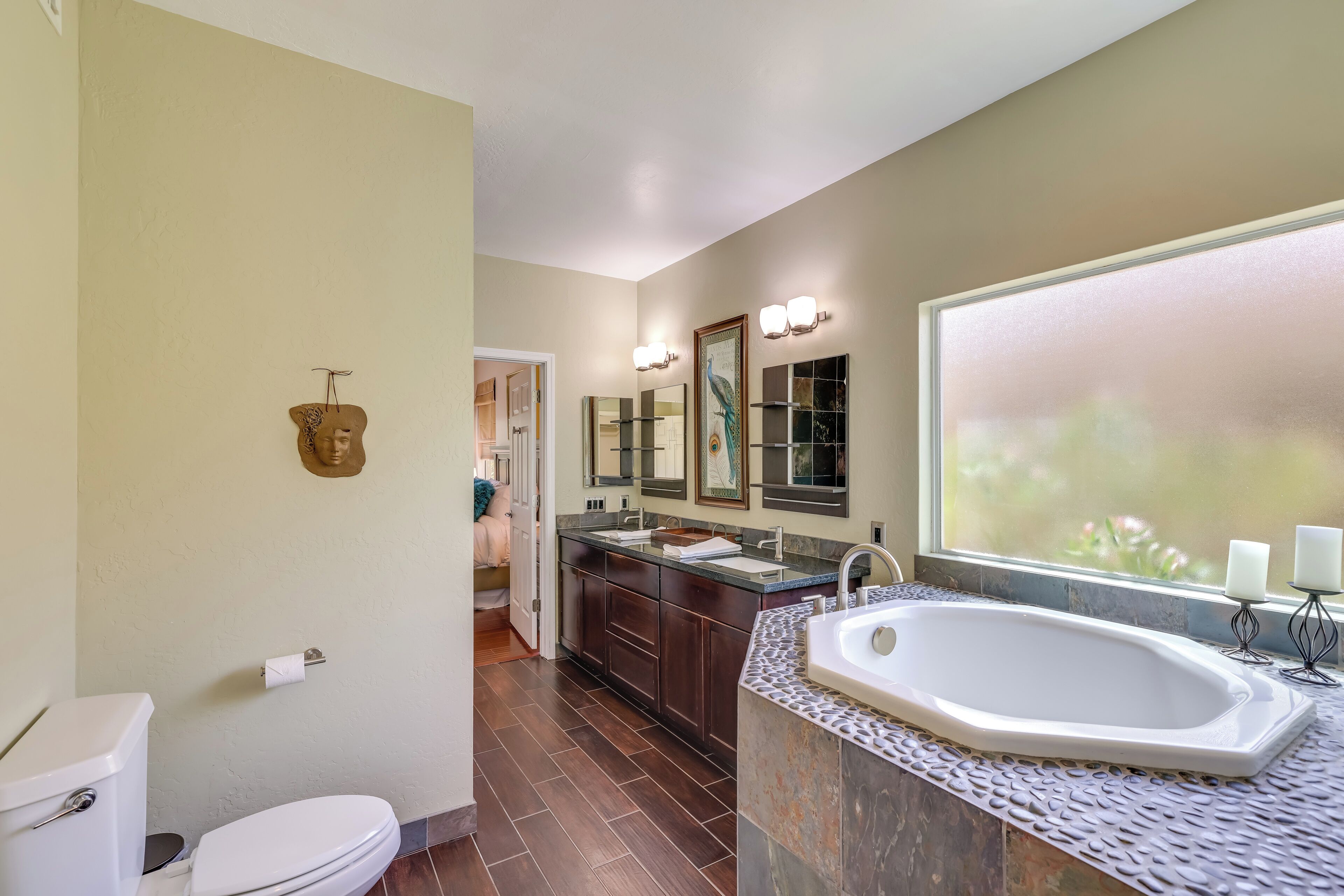 A modern bathroom with a large bathtub, a vanity with a sink, and a mirror above the vanity.