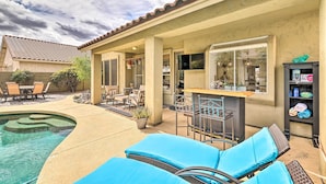 A backyard with a swimming pool, outdoor seating, and a bar area. - Golf & Unwind Poolside: Cave Creek Group Retreat! (Cave Creek)