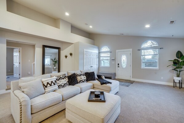 A spacious living room with a sectional sofa, a coffee table, and a large window. - Near Red Rocks: Golden Getaway w/ Deck! (Golden)