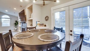 Un coin repas avec une table ronde, quatre chaises et un lustre.