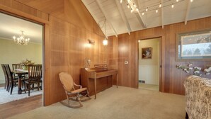 A room with wooden paneling, a desk, a rocking chair, and a bed. - Cozy Hillsdale Home ~ 1 Mi to Baw Beese Lake! (Hillsdale)