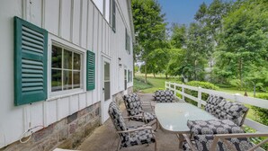 A patio with a table and chairs, a white fence, and a view of a green landscape. - Cozy Hillsdale Home ~ 1 Mi to Baw Beese Lake! (Hillsdale)