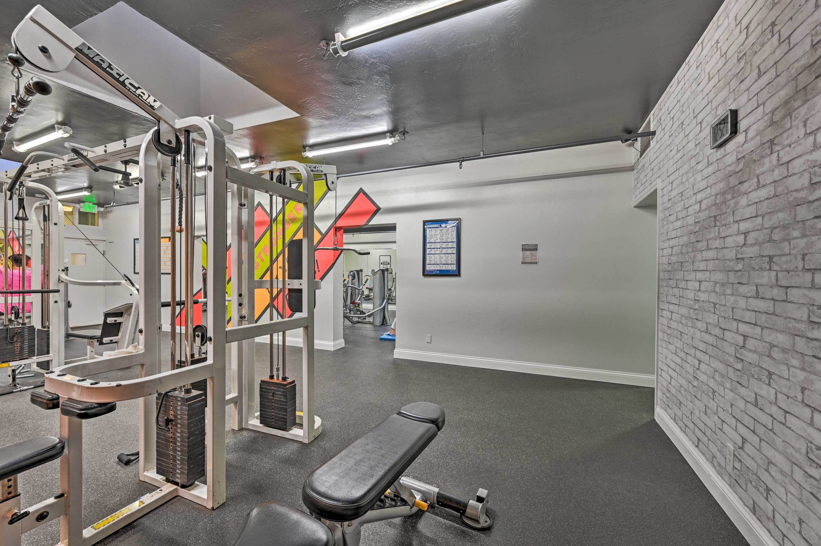 Un gimnasio con equipo de ejercicio, una banca y una pared de ladrillo.