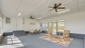 A covered patio area with two ceiling fans, a table with chairs, and a rug. - Charming Gadsden Home w/ Golf Course Views! (Gadsden)