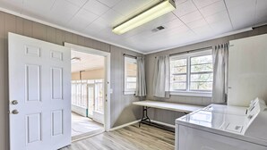 A laundry room with a white door, a window with curtains, and a table. - Charming Gadsden Home w/ Golf Course Views! (Gadsden)