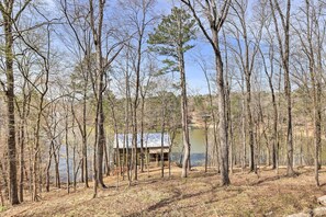 A cabin surrounded by tall trees and a body of water. - Cozy Studio Cabin in Tallassee w/ Water View! (Tallassee)