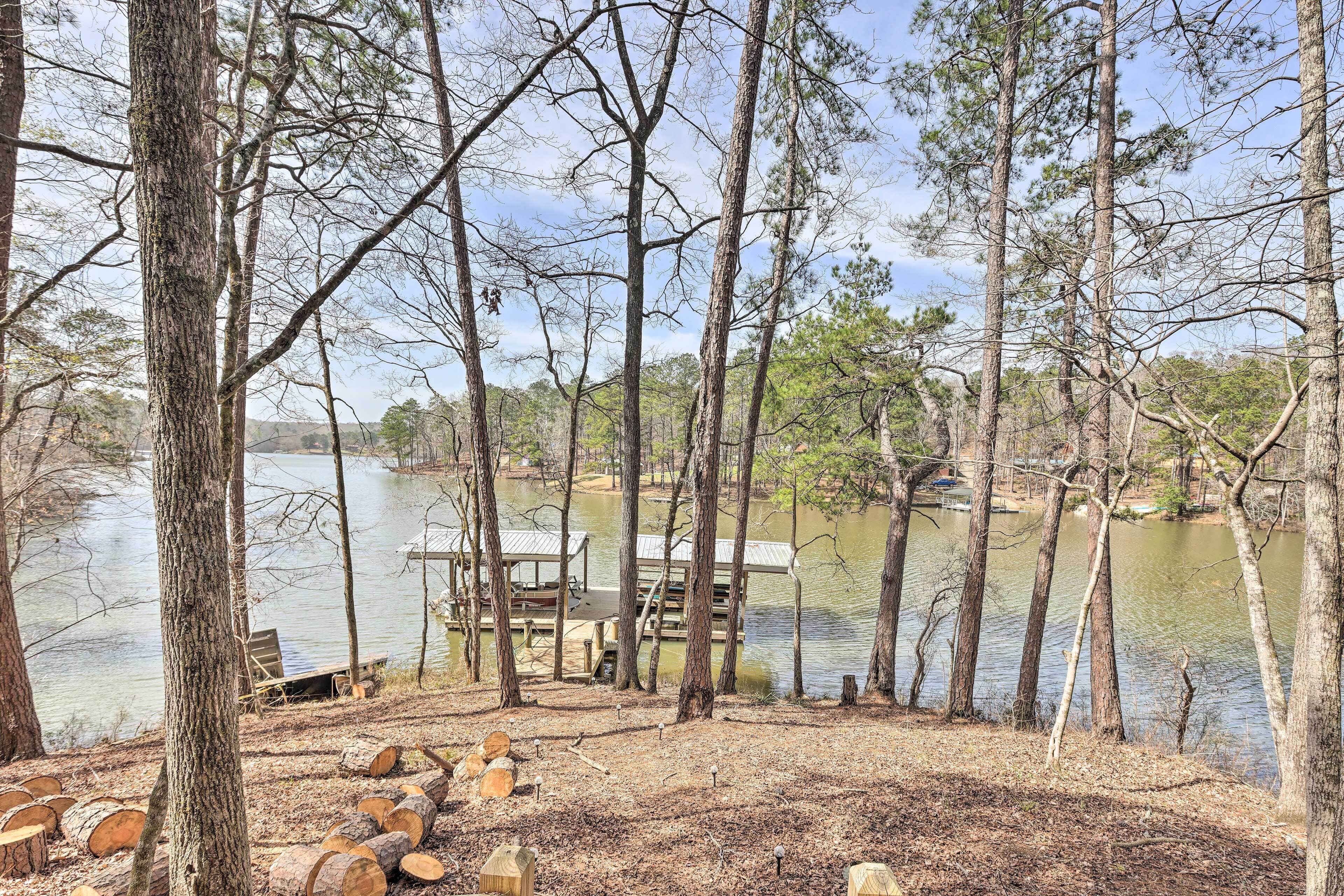 A lakeside cabin with a dock and a covered seating area.