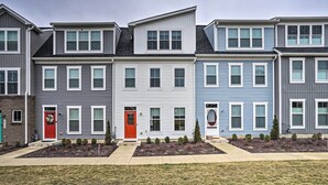 A row of townhouses with a red door, white trim, and a small front yard with shrubs. - Modern Townhome 4 Mi to Downtown Frederick! (Frederick)