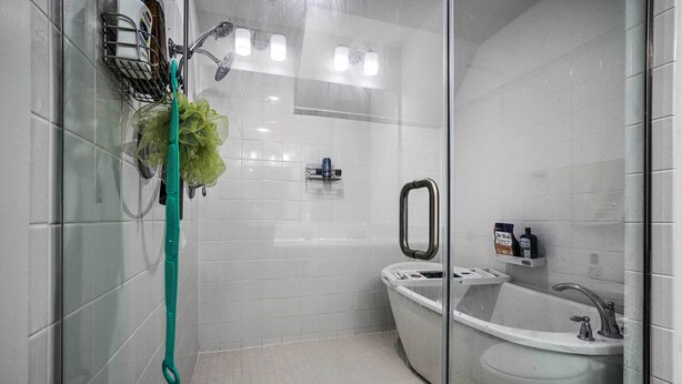 A modern bathroom with a glass-enclosed shower, a white bathtub, and a glass-enclosed sink. - Modern Townhome 4 Mi to Downtown Frederick! (Frederick)