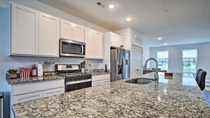 A modern kitchen with white cabinets, stainless steel appliances, and a granite countertop. - Modern Townhome 4 Mi to Downtown Frederick! (Frederick)