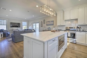A spacious kitchen with white cabinetry, a large island, and modern appliances. - Long Branch Home < 1 Mi to Beach! (Long Branch)