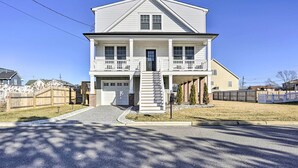 Ein zweistöckiges Haus mit einer Veranda, einer Garage und einer Treppe, die zum zweiten Stock führt.