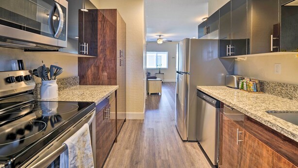 A modern kitchen with a stainless steel stove, granite countertops, and dark wood cabinetry. - Pahrump Vacation Rental Apartment! (Pahrump)