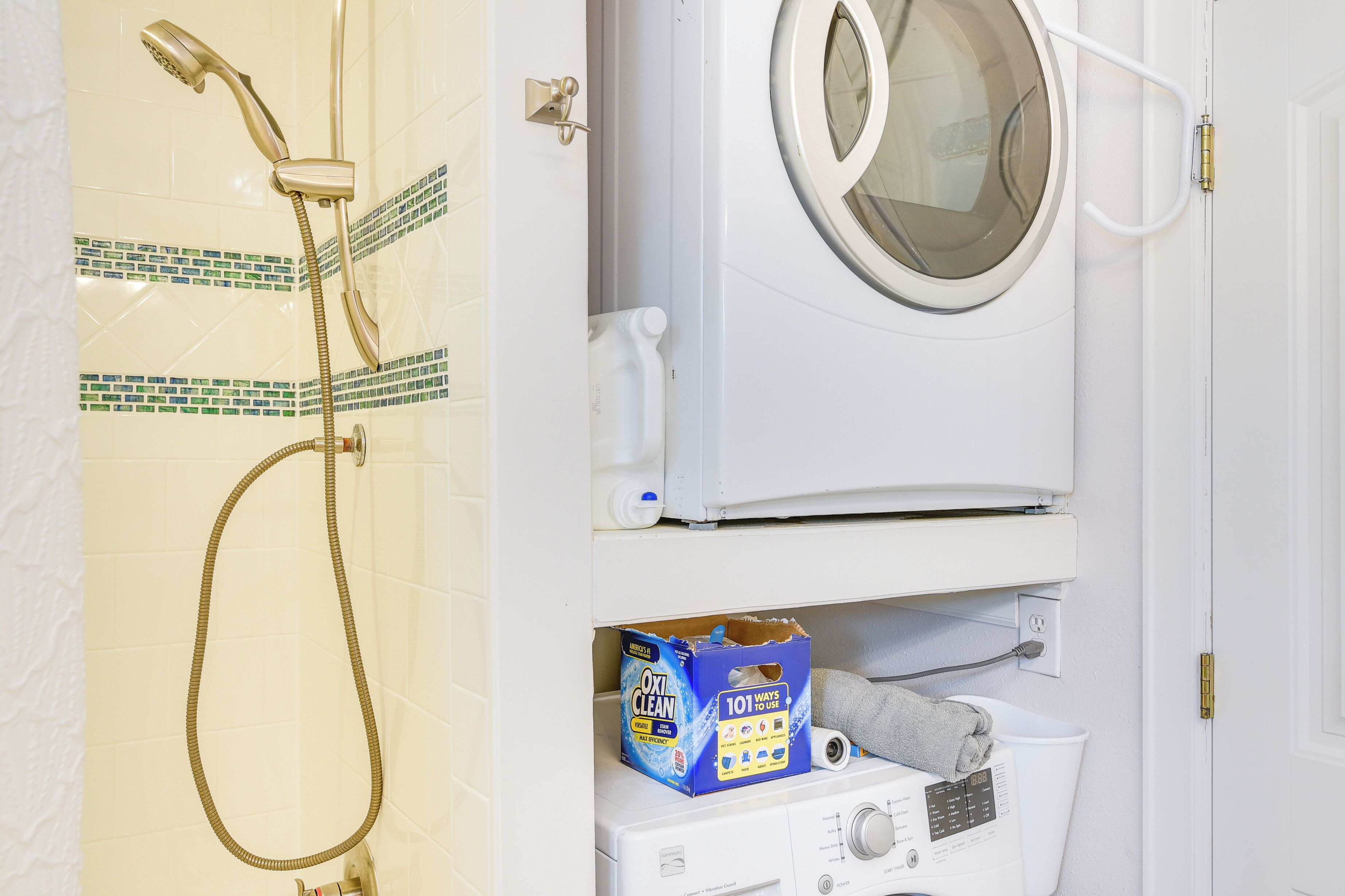 Ein Badezimmer mit Dusche, Waschmaschine und Toilette.