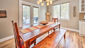 Un coin repas avec une table en bois, des chaises et un lustre.