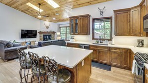 Una cocina moderna con armarios de madera, una isla grande y una chimenea.