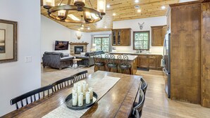 Una cocina amplia con armarios de madera, un comedor con una mesa larga y una chimenea.