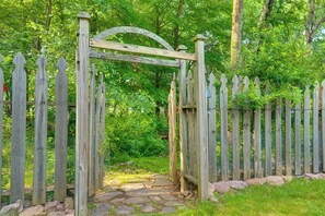 A wooden gate with a curved top, surrounded by a picket fence, leading into a wooded area. - Beautiful Effort Escape w/ Private Hot Tub! (Effort)