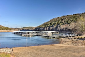 A lakeside lodge with a dock extending into the water, surrounded by forested hills.
