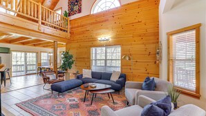 A spacious living room with a high ceiling, wooden walls, and large windows. - Family-friendly Cabin By Golf Course & Marina (Eureka Springs)