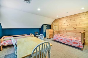 Une chambre avec deux lits simples, une table en bois et une chaise.