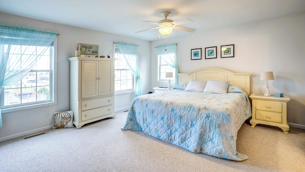 A bedroom with a bed, a nightstand, a dresser, and a ceiling fan. - Bowers Beach Vacation Rental: 2 Blocks Away! (Frederica)