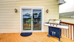 A deck with a grill and a sliding glass door to a covered patio. - Bowers Beach Vacation Rental: 2 Blocks Away! (Frederica)
