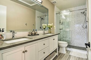 A modern bathroom with two sinks, a toilet, and a glass-enclosed shower. - Phoenix Home: Heated Pool, Patio & Mountain Views! (Phoenix)