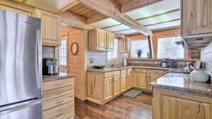 Une cuisine spacieuse dotée de meubles en bois, d’un réfrigérateur en acier inoxydable et d’un grand îlot central avec un évier.