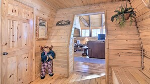 Un intérieur en bois avec une porte en bois, un jouet en peluche et une pancarte « Bienvenue ».
