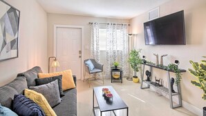 A modern living room with a sofa, coffee table, and a TV mounted on the wall. - Fort Lauderdale Apt Near Beaches & Shopping! (Fort Lauderdale)