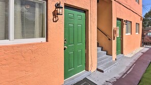 A building with a green door, a window with blinds, and a staircase leading to the entrance. - Fort Lauderdale Apt Near Beaches & Shopping! (Fort Lauderdale)
