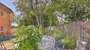 An outdoor patio area with a wooden fence, a chair, and a table. - Fort Lauderdale Apt Near Beaches & Shopping! (Fort Lauderdale)