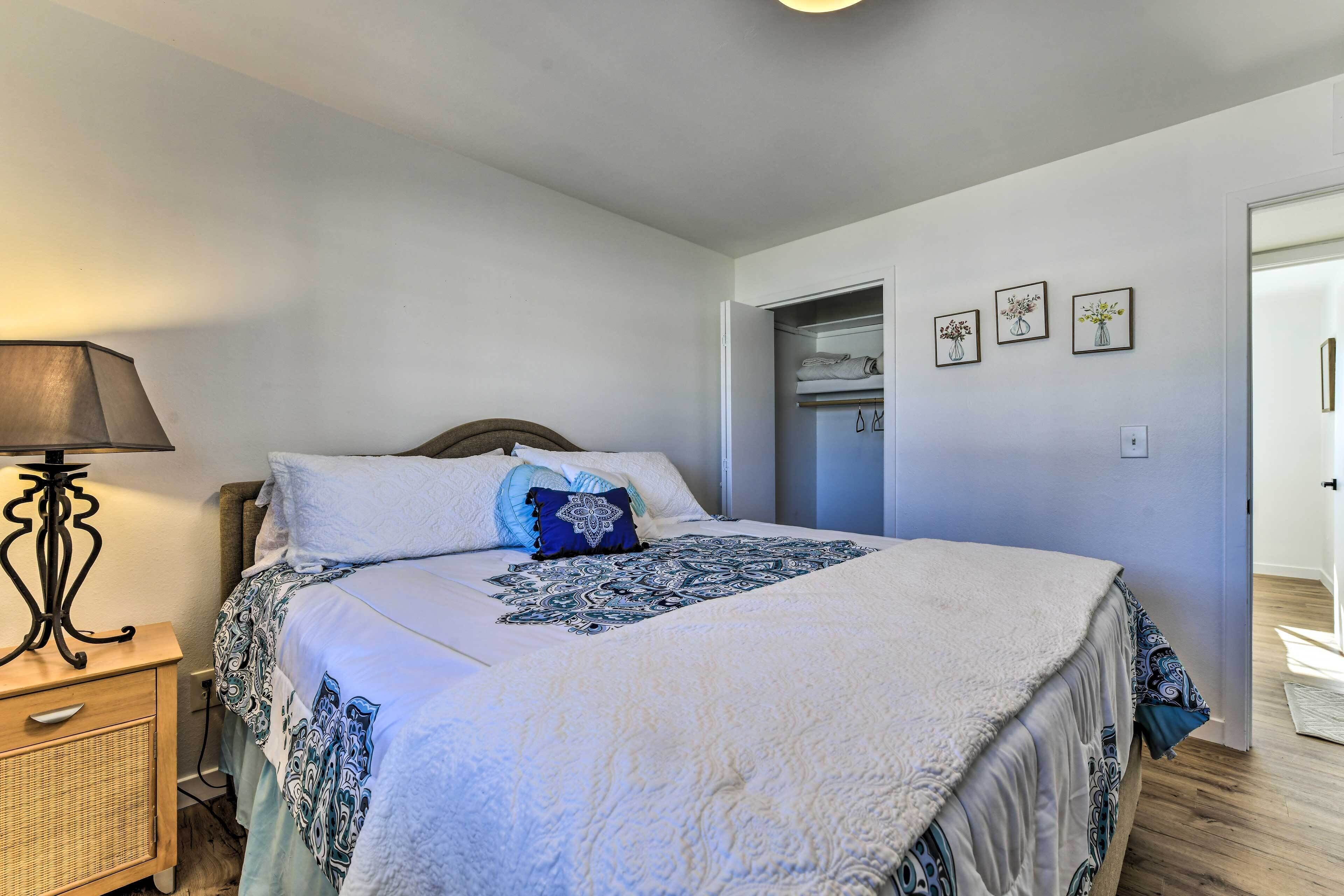 A bedroom with a bed, bedside table, lamp, and a wardrobe.