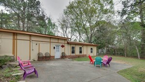 A building with a beige exterior, a front door, and windows. There are outdoor chairs and a table in front. - Hazlehurst Vacation Rental w/ Shared Yard! (Hazlehurst)