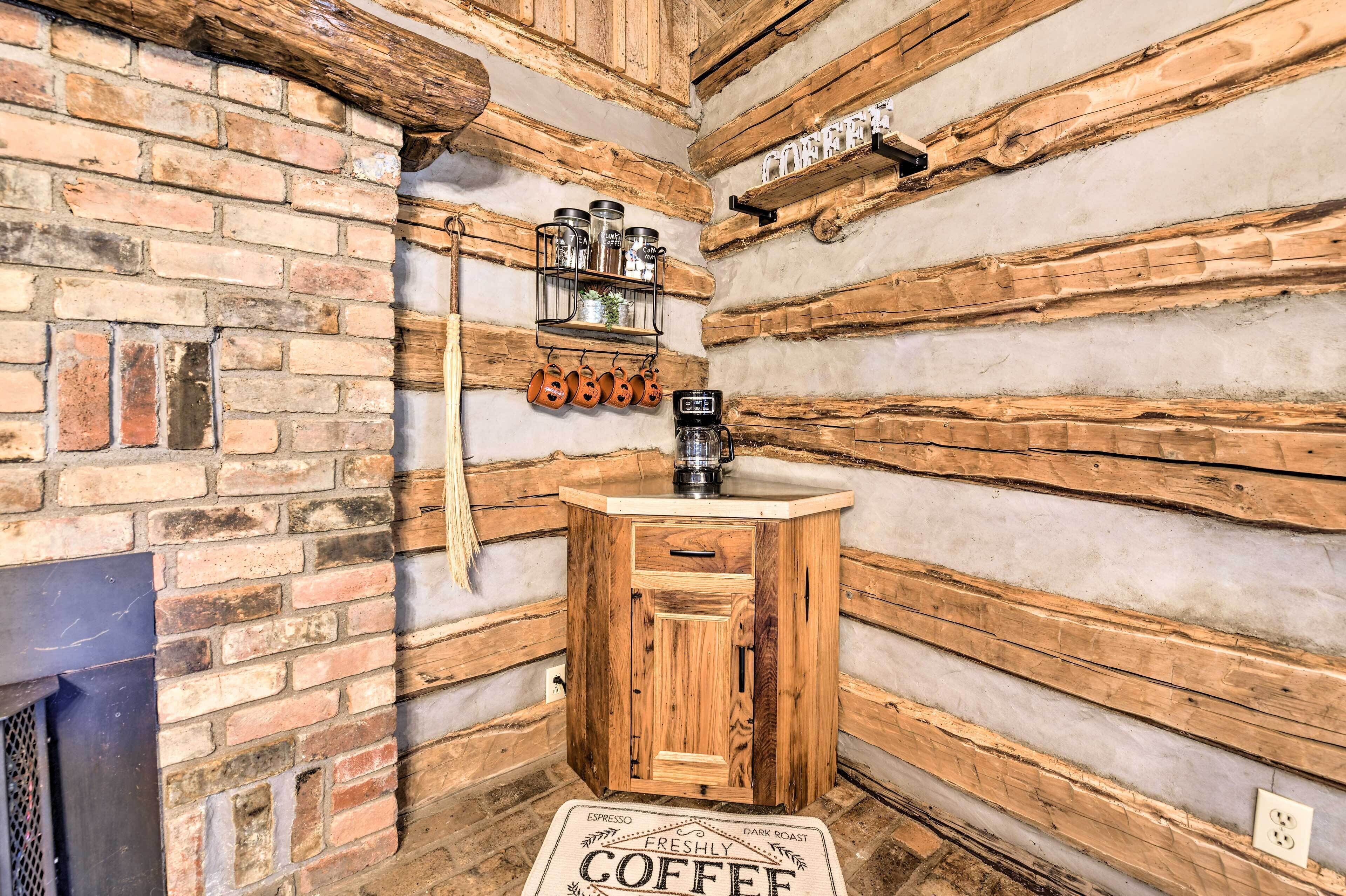 A rustic coffee bar with a wooden cabinet, a coffee machine, and jars of coffee.