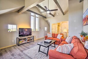 A spacious living room with a large TV, a sofa set, and a ceiling fan. - Family-friendly Williams Cabin w/ Gas Grill (Williams)