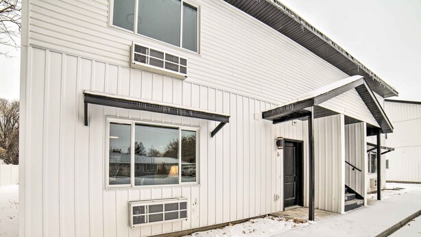 A white building with a covered entrance and a garage door. - Cozy Blackfoot Apartment: Pets Welcome! (Blackfoot)