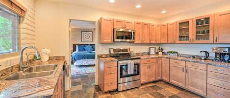 A modern kitchen with granite countertops, stainless steel appliances, and wooden cabinets.