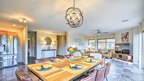 A spacious dining area with a long wooden table, leather chairs, and a chandelier. - Patio & Panoramic Desert Views: Sedona Getaway! (Sedona)