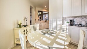 A kitchen with white cabinets, a round table with chairs, and a dining area with a white table and chairs. - Pool & Pickleball Access: Quiet Scottsdale Home! (Scottsdale)