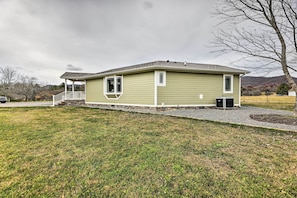 A single-story house with a covered porch, a small attached garage, and a well-maintained lawn.