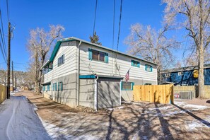 A two-story house with a garage, a wooden fence, and a clear sky. - Pet-friendly Duplex - Near Skyline Drive! (Canon City)