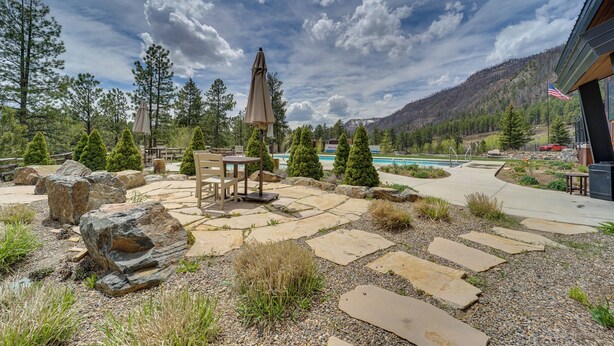 A patio area with stone flooring, outdoor furniture, and a view of a mountain and pool. - Durango Lofted Studio ~ 9 Mi to Purgatory Resort! (Durango)